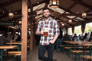 Casual men’s outfits for Oktoberfest in Germany with plaid shirt jeans and boots in festive beer tent